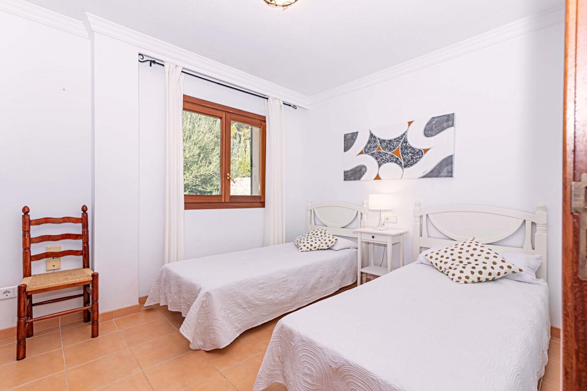 A bedroom with two twin beds and a chair