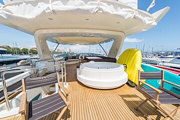 A yacht with a jacuzzi and chairs on the deck