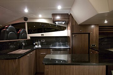 A kitchen with wooden cabinets and black counter tops