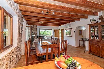 A dining room table with a bowl of fruit on it