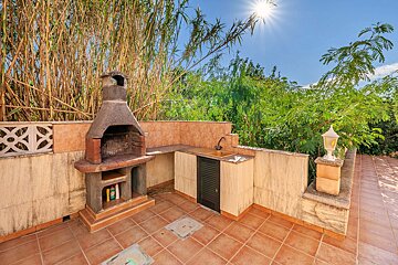 The sun is shining brightly over a barbecue area