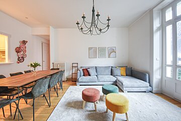 A living room with a sectional couch and a chandelier