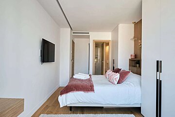 A bedroom with a large bed and a flat screen tv