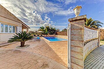 A gated entrance to a house with a swimming pool