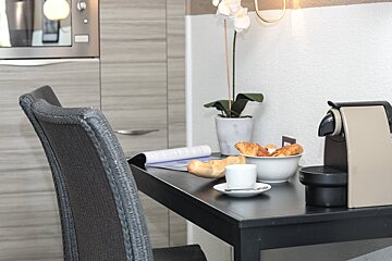 A table with a cup of coffee and croissants on it