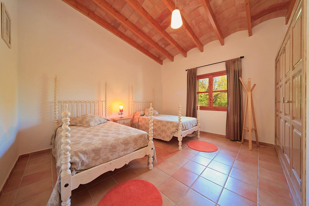 A bedroom with two beds and a window