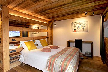 A bedroom with a bunk bed and a painting on the wall