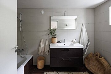 A bathroom with a sink and a mirror above it