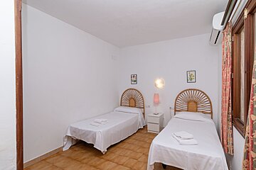 A bedroom with two beds and a picture of flowers on the wall