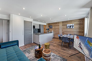 A living room with a blue couch and a flat screen tv