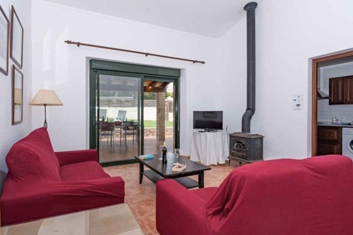 A living room with red furniture and a television