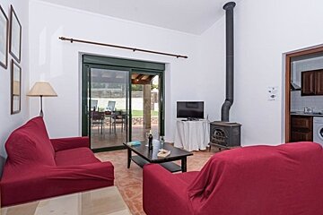 A living room with red furniture and a television