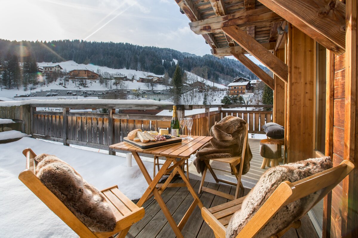 A bottle of champagne sits on a table on a balcony