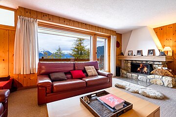 A living room with a red couch and a fireplace