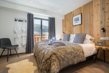 A bedroom with a fur blanket on the bed