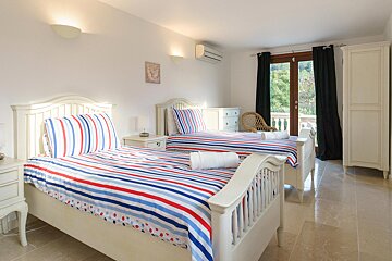 Two twin beds in a bedroom with striped sheets