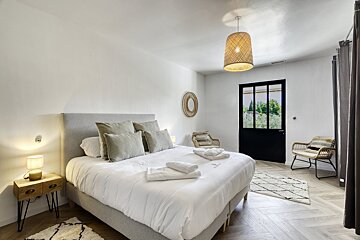 A bedroom with a king size bed and a chair