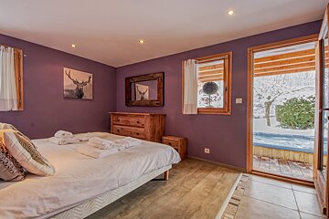 A bedroom with purple walls and a deer painting on the wall