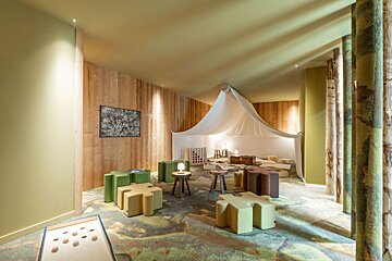 A bedroom with wooden walls and a bed with a yellow headboard