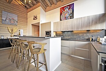 A kitchen with a painting of a cow on the wall