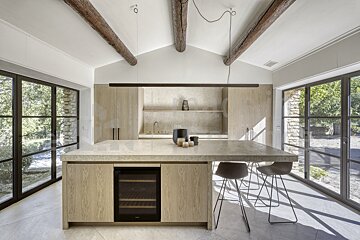 A kitchen with a large island and a wine cooler