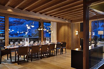 A dining room with a long table and chairs
