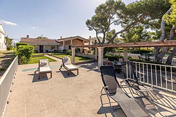 A patio with chairs and tables in front of a house