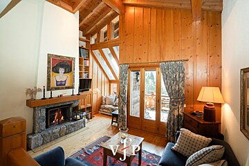 A living room with a fireplace and a painting of a woman on the wall