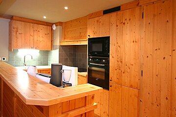A kitchen with wooden cabinets and a black oven