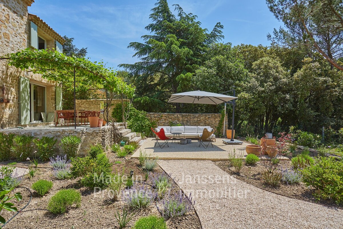 A patio with a couch and an umbrella in front of a house that says made in provence