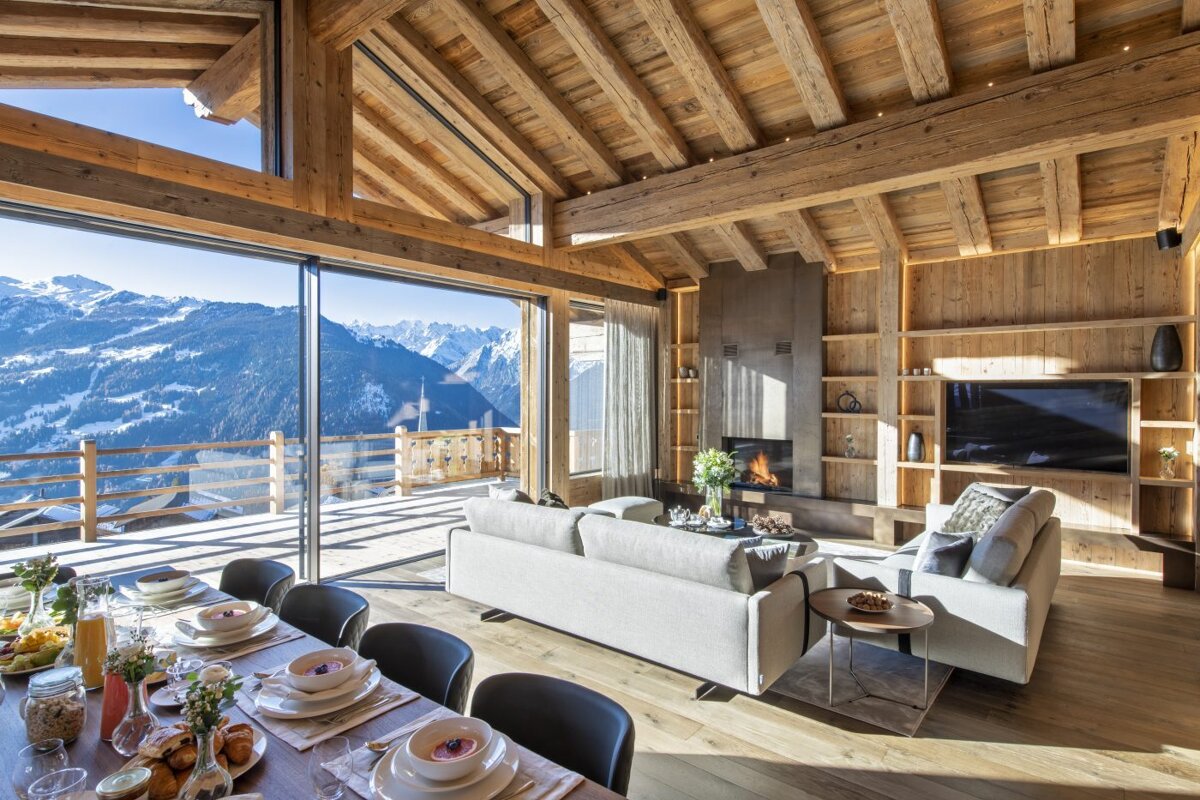 A living room and dining room with a view of the mountains