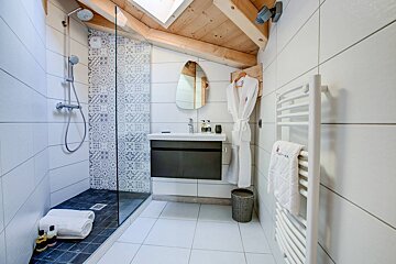 A bathroom with a walk in shower and a sink