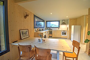 A kitchen with a table and chairs and a picture on the wall