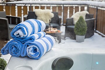 Blue and white striped towels stacked on top of a hot tub