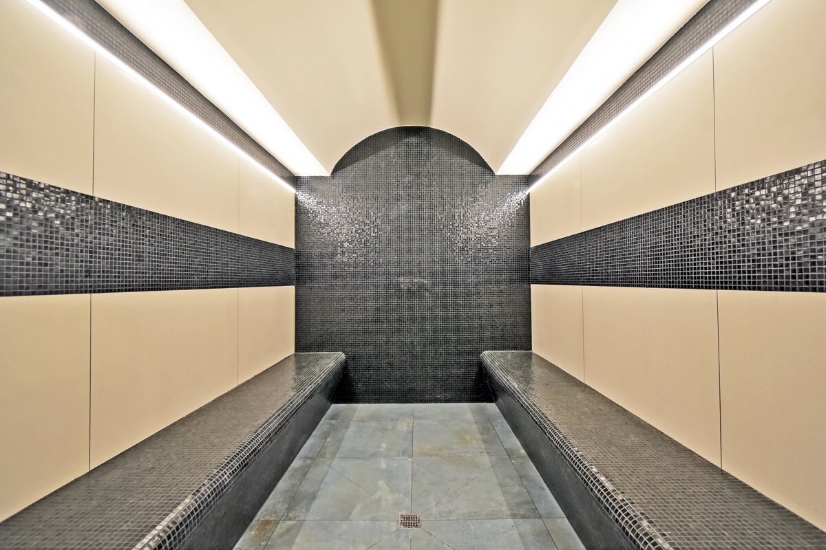 A long narrow room with black tiles on the walls