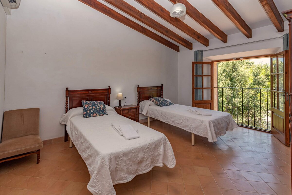 A bedroom with two twin beds and a balcony