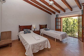 A bedroom with two twin beds and a balcony