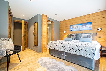 A bedroom with a painting on the wall above the bed