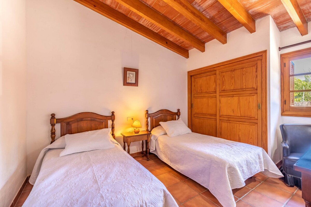 A bedroom with two beds and a picture on the wall