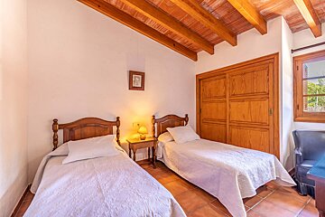 A bedroom with two beds and a picture on the wall