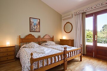 A bedroom with two beds and a mirror on the wall