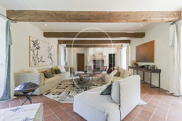 A living room with a fireplace and wooden beams