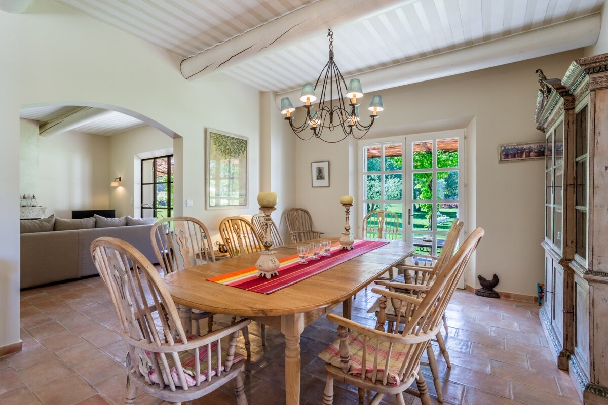 A dining room with a table and chairs and a chandelier