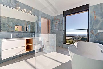 A bathroom with blue tiles and a bathtub