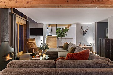 A living room with a large sectional couch and a fireplace
