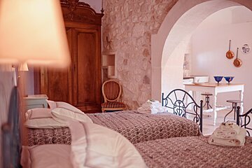 A bedroom with two beds a chair and a table