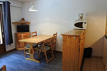 A kitchen with a table and chairs and a microwave