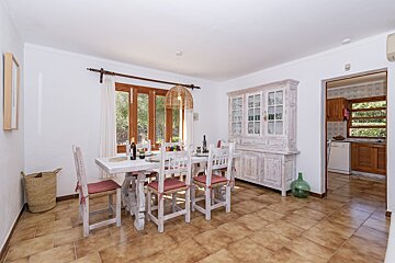 A dining room with a white table and chairs