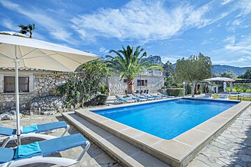 A large swimming pool surrounded by lounge chairs and umbrellas