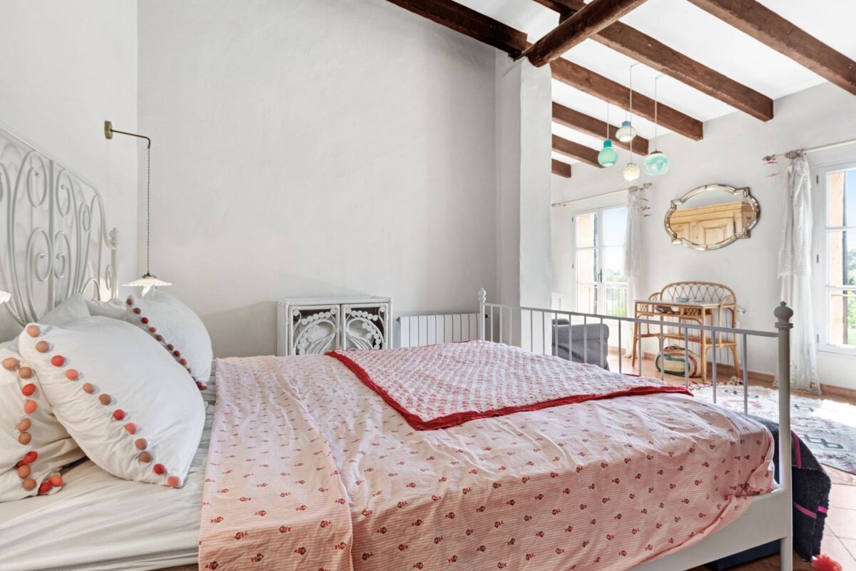 A bedroom with a large bed and a desk